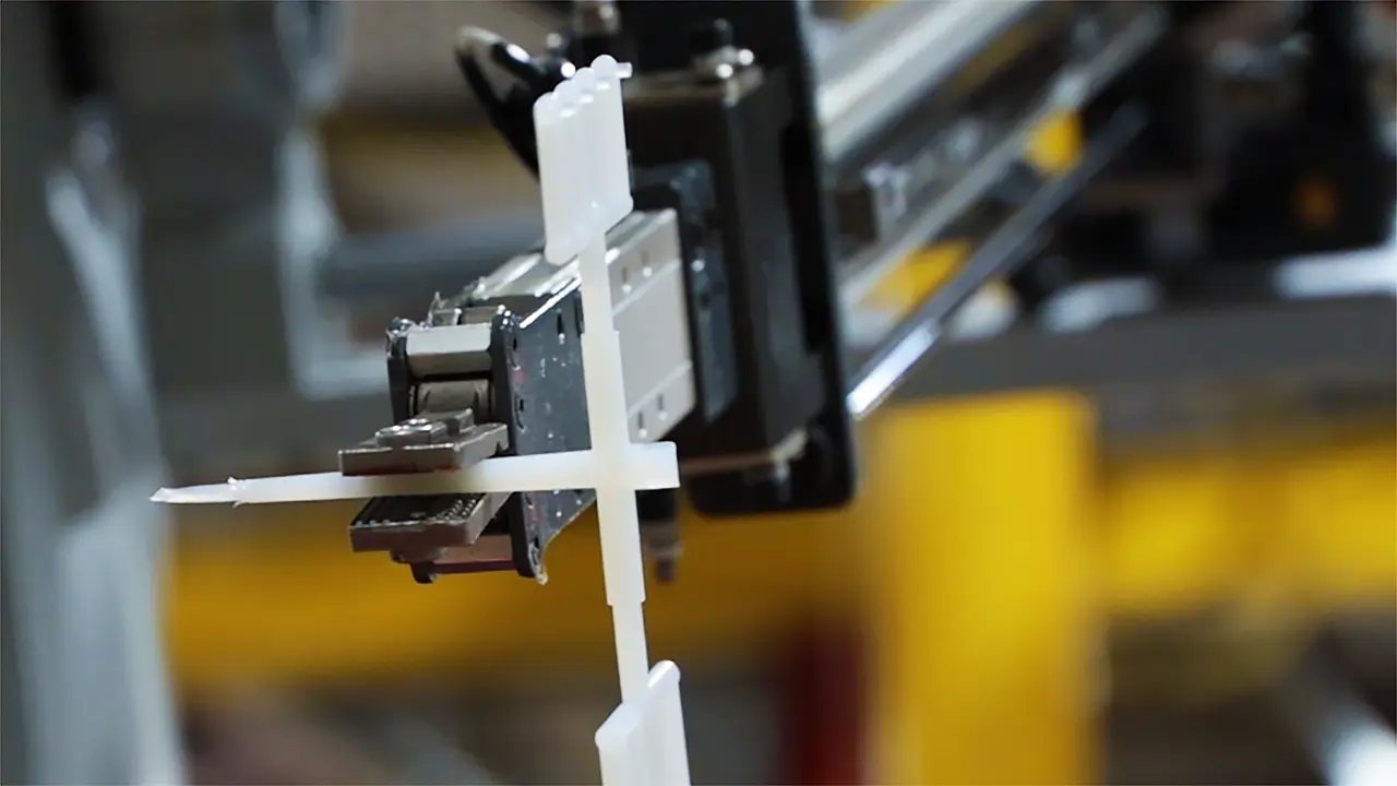 Sprue picker holding newly injection-molded pieces